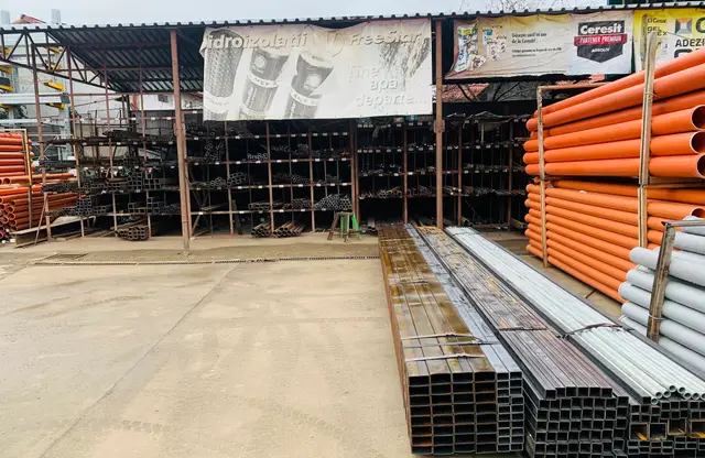 Depozit acoperit cu profile metalice, țeavă rectangulară și tuburi PVC portocalii